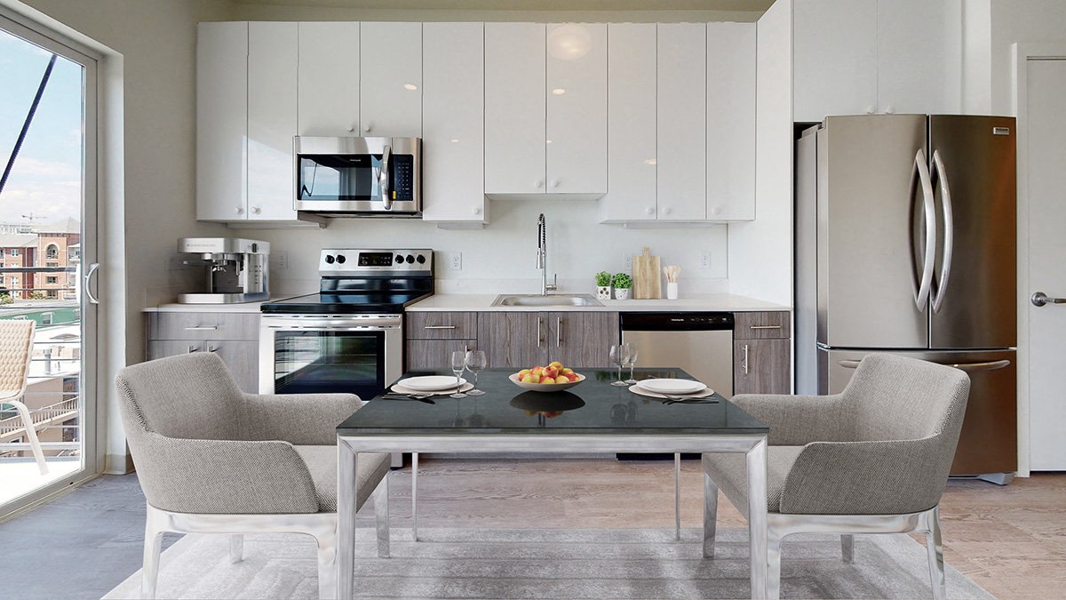 A modern kitchen with a dining table set for two.